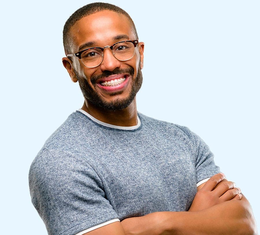 Adult patient with clear ceramic braces smiling confidently